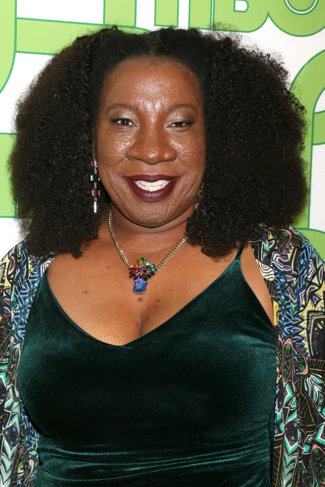 Tarana Burke, founder of the Me Too movement, wearing a green velvet dress and colorful necklace.