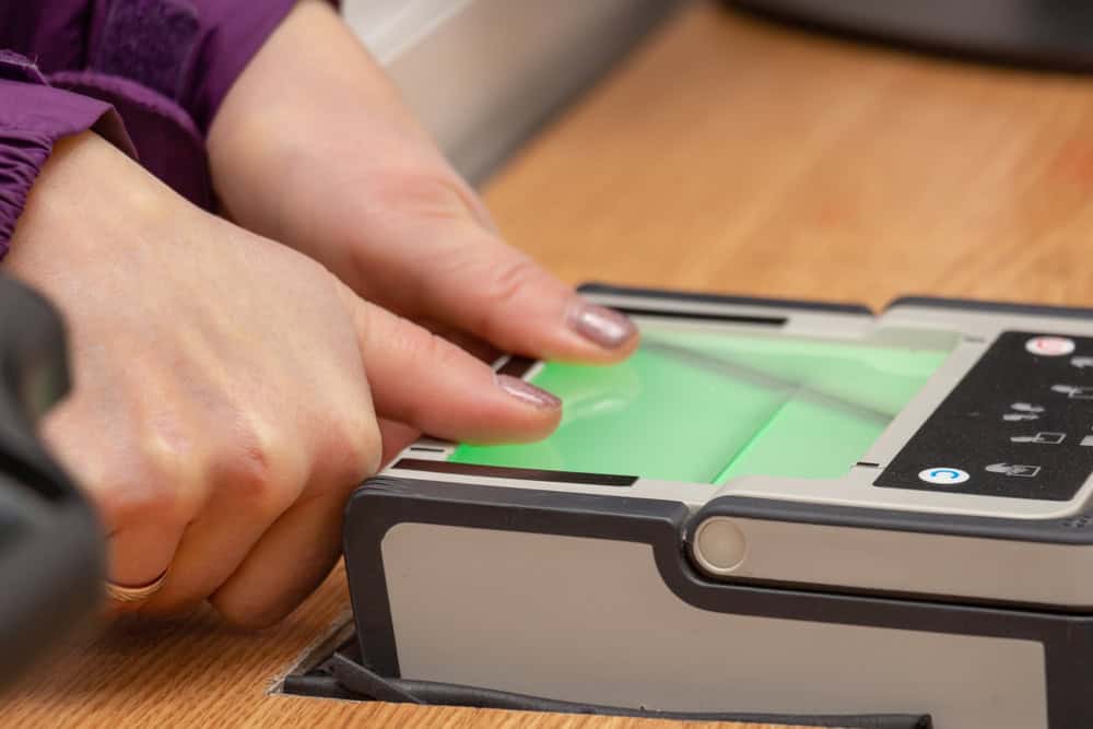 Digital fingerprint scanner glowing on a biometric device, symbolizing identity verification.