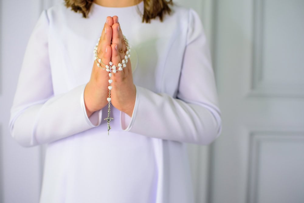 Close-up of hands holding a rosary, in the context of the Catholic Church sexual abuse litigation.
