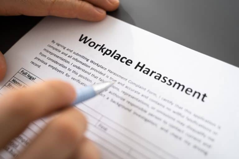"Close-up of a person filling out a workplace harassment complaint form.