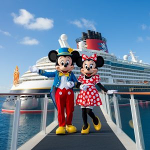 Mickey Mouse and Minnie Mouse posing in front of a Disney Cruise ship.