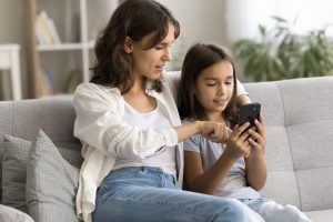 A mother showing her daughter how to safely navigate online.