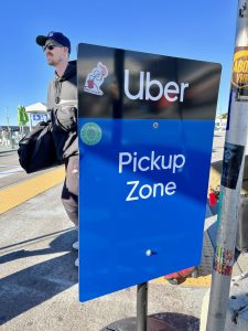 A passenger stands at an Uber pickup zone. The Uber sexual assault attorneys we work with may help you understand your legal rights in filing a claim.