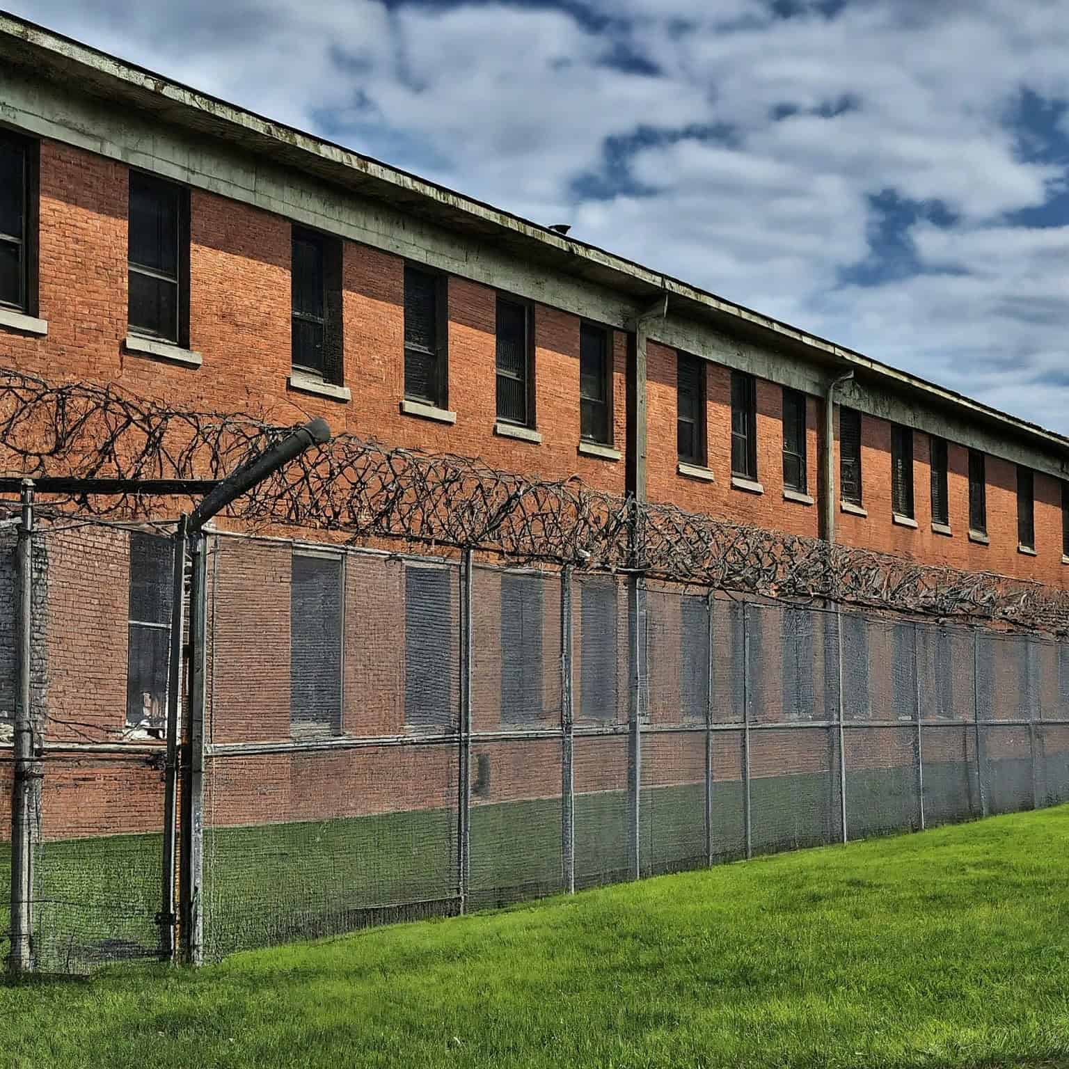 AI-generated image representative of a juvenile detention center behind barbed wire.