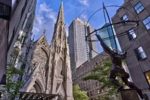 Facade of St. Patrick's Cathedral in Manhattan, with the statue of Atlas in the foreground. The Cathedral is part of the Roman Catholic Archdiocese of New York.