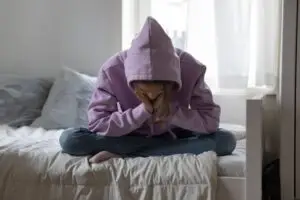 a photo of a depressed teenager, symbolic of a child placed in a foster home setting.