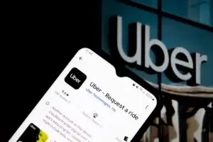A smartphone reveals the Uber app. "Request a ride" prompt is shown, in the context of Uber sexual assault cases, numbering more than 400,000 incidents according to a recent New York Times investigation.