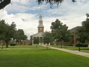 New Orleans Baptist Theological Seminary chapel with white steeple, clock tower, and landscaped campus