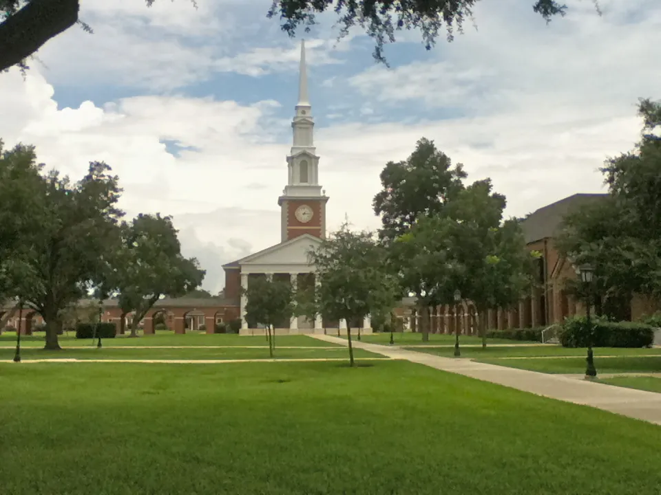 New Orleans Baptist Theological Seminary chapel with white steeple, clock tower, and landscaped campus