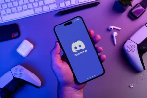 A person holding a smartphone with the Discord app open
