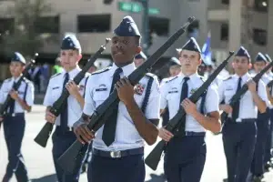 Survivors Rights | Sexual Misconduct by Jr. ROTC Instructors Found Widespread, Government Report Says High school JROTC cadets in light blue uniforms march in formation during a parade, each carrying a drill rifle