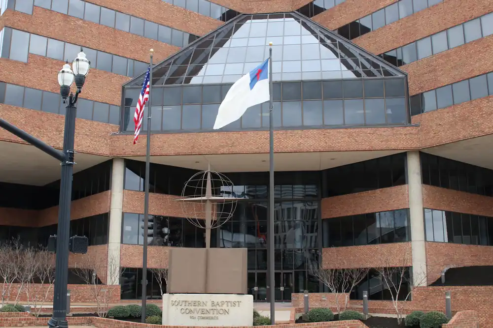 Southern Baptist Convention headquarters building in Nashville with American and Christian flags flying outside.