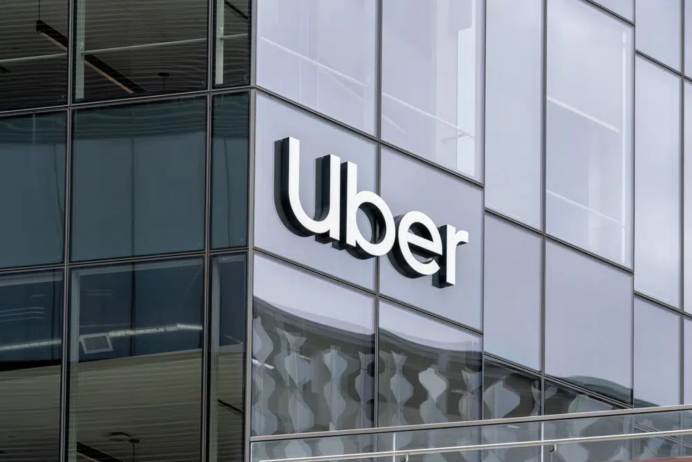 Uber headquarters building with large Uber logo on glass exterior.