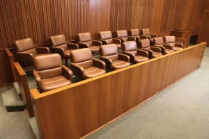 Empty jury box with leather chairs inside a courtroom.
