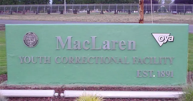 The entrance sign of MacLaren Youth Correctional Facility in Oregon, featuring the Oregon Youth Authority logo and the establishment year 1891.