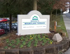 A welcome sign for Mountlake Terrace, Washington, with arrows pointing to Lake Ballinger and City Center,