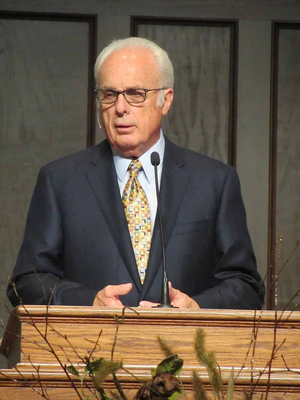 Pastor John MacArthur speaking at a pulpit during a church service, as relevant to a lawsuit involving Grace Community Church.