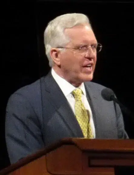 Apostle D. Todd Christofferson of The Church of Jesus Christ of Latter-day Saints speaking at a pulpit; his younger brother, Wade S. Christofferson, has been charged with federal crimes alleging attempted sexual exploitation of children in Utah and Ohio.