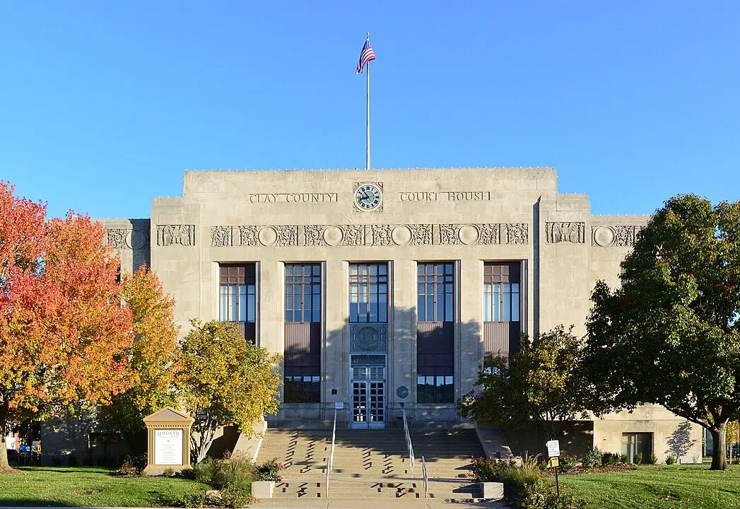 South side of the Clay County Courthouse in Missouri, featuring its Art Deco façade, central clock, and surrounding autumn trees.