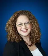 Massachusetts State Senator Rebecca L. Rausch (D-Needham) smiling in a professional headshot against a blue background.
