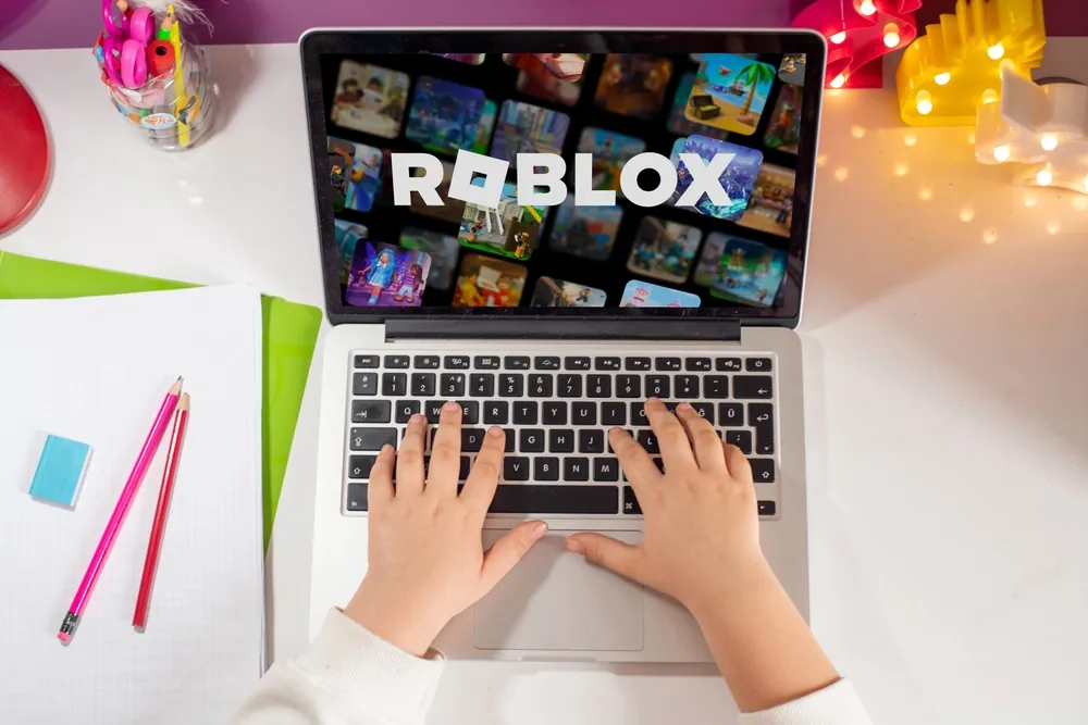 Child using a laptop to play Roblox, highlighting safety concerns about the gaming platform.