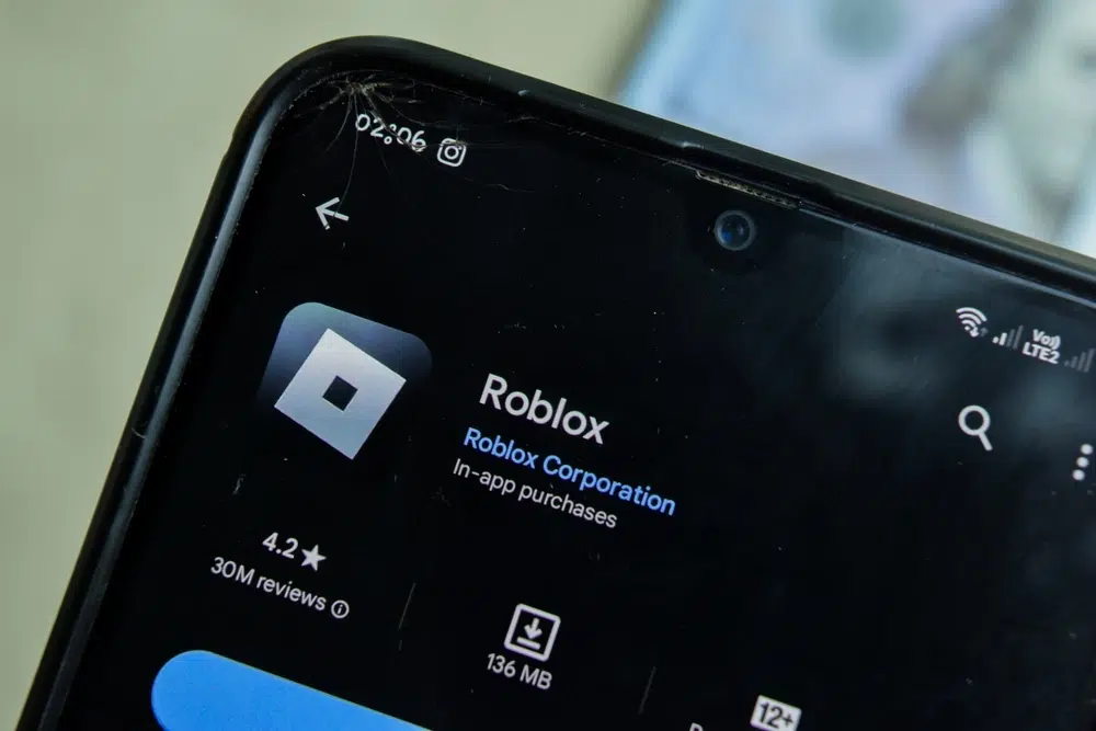 Mobile phone screen displaying the Roblox app page on the Google Play Store, showing the Roblox logo, rating, download size, and interface details.