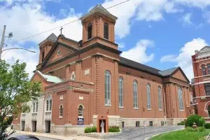 St. Joseph Cathedral Complex in the Cathedral Hill Historic District of Buchanan County, Missouri, showing the west and south brick facades under a blue sky.