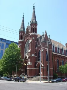 The Cathedral of St. Paul in Birmingham, Alabama, a historic red brick Catholic cathedral with twin spires and a large stained glass window.