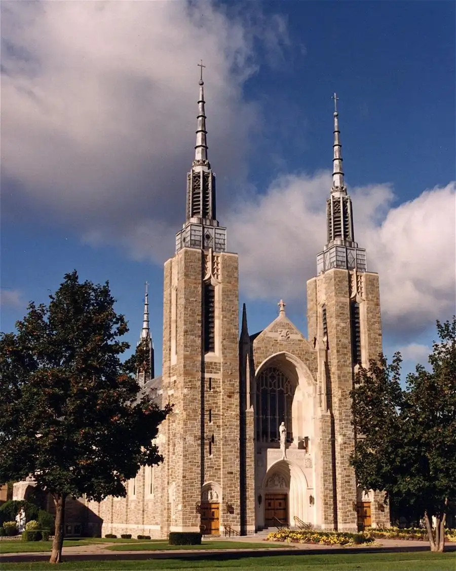 St. Mary's Cathedral in Ogdensburg, New York, featuring twin stone towers and a large central entrance under a bright sky.