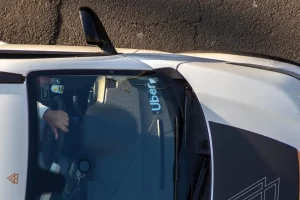 Overhead view of an Uber vehicle with the driver’s hand on the steering wheel.