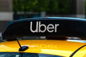 Uber logo displayed on the roof sign of a rideshare vehicle parked on a city street.