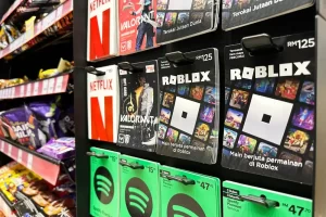 Roblox gift cards displayed on a store rack alongside other digital gaming and streaming gift cards, representing how children can access the Roblox platform through retail purchases.
