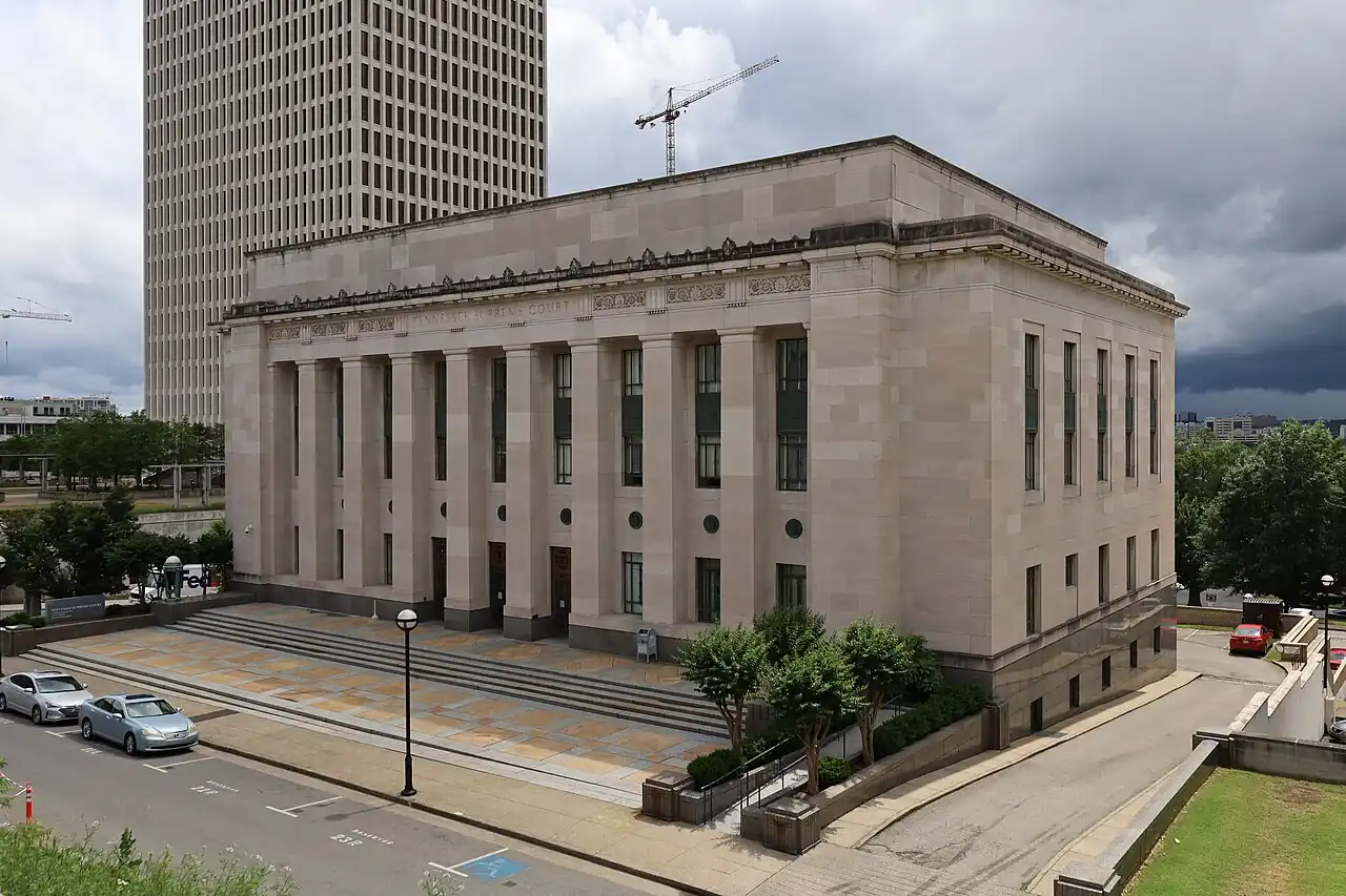Exterior view of the Tennessee Supreme Court building in Nashville, a large stone courthouse with columns and steps, photographed on an overcast day.