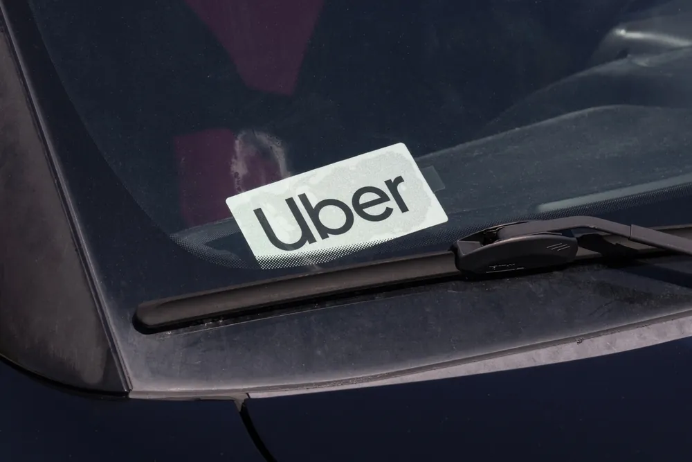 Uber logo displayed on the windshield of a rideshare vehicle, representing Uber amid ongoing sexual assault litigation and rider safety concerns.