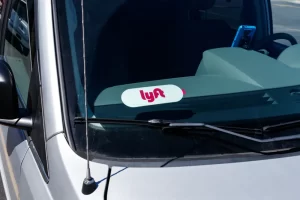 lyft-car-dashboard Lyft logo displayed on a rideshare vehicle dashboard, representing Lyft ride activity amid passenger safety concerns.