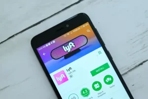 Smartphone displaying the Lyft app, accompanying coverage of a Kentucky Lyft driver criminal case and related Lyft sexual assault litigation.