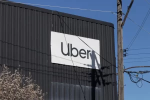 Uber logo displayed on the exterior of a dark industrial building, representing the rideshare company amid ongoing sexual assault litigation.