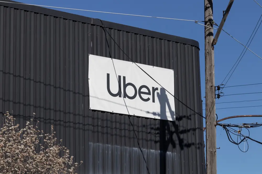 Uber logo displayed on the exterior of a dark industrial building, representing the rideshare company amid ongoing sexual assault litigation.