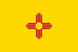 new-mexico-flag Flag of New Mexico featuring a red Zia sun symbol centered on a yellow field.